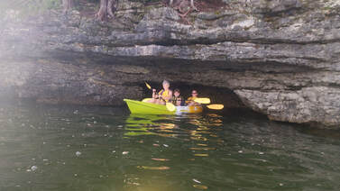 Three people kayaking in a cave
