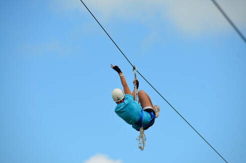 Person zip lining in the sky