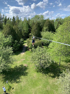 Woman zip lining into the woods